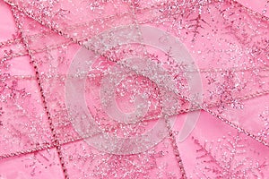 Abstract textured background of pink net ribbon with glitter snowflakes