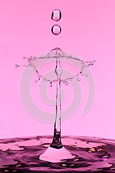 Close up detail of a pink water drop collision