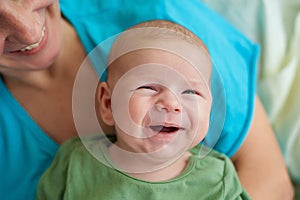 Close-up detail portrait of cute little peaceful smiling baby boy face