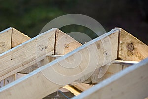 Close-up detail of roof frame of rough wooden lumber beams on background of misty mountain landscape in ecological area. Building