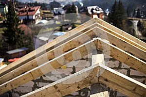 Close-up detail of roof frame of rough wooden lumber beams on background of misty mountain landscape in ecological area. Building