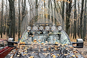 Close-up detail view of custom made roof rack bar with extra headlight mounted on roof of heavy duty pick up suv car