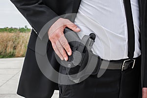 Close-up detail view of hand with gun in bandolier belt