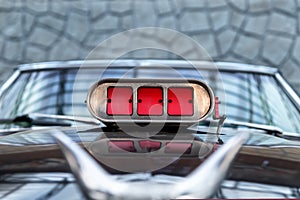 Close-up detail view of old classic vintage retro american supercharged muscle car red intake throttle valve on hood