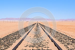 Close up detail view of train tracks leading through the desert near the city of Luderitz in Namibia, Africa. Selective focus on f