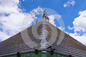 Close-up detail view of weather vane. Abstract outdoor view of the top of an ancient house roof made of grey slates