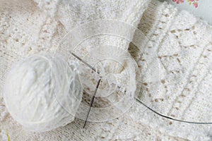 Close up detail of white wool woven handicraft knit baby sweater design texture and clew.