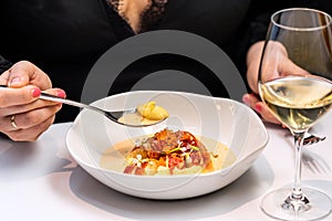 Close up detail of female hands next to lobster dish in fancy restaurant