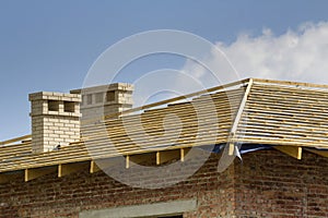 Close-up detail of wooden roof of new brick house with two white
