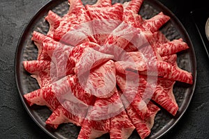 A close up detailed image of sliced Japanese wagyu beef in a ceramic plate prepared for Shabu Shab