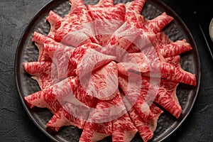 A close up detailed image of sliced Japanese wagyu beef in a ceramic plate prepared for Shabu Shab photo