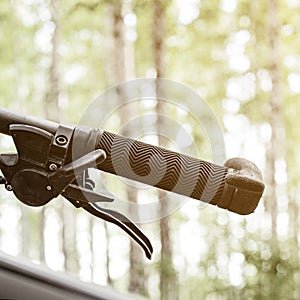 close-up details of a bike against a blurred forest background, front and back background blurred with bokeh effect