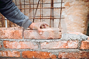 Close up details of worker, bricklayer placing and adjusting bricks. Professional worker building exterior walls