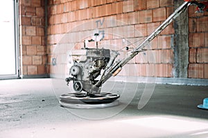 Close up details of construction worker finishing concrete screed with power trowel machine