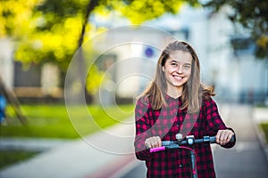 Close up details of electric scooter on the road. Ecological and urban transport in the city. Young smiling woman riding a electri