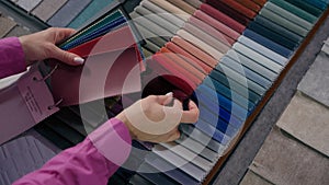 Close up details fabric swatches different trend colors sample collection on table unrecognizable woman customer