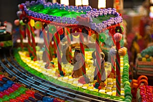 Close-up details of gingerbread Christmas scenery with human figurines dressing up the traditional vintage winter clothes standing