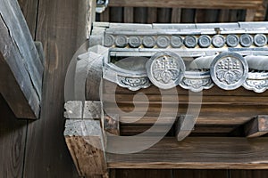 Close up details of Hanagawara or roof tile ornamentation with floral and plant designs in traditional Japanese architecture