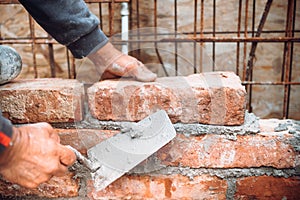 Close up details of industrial bricklayer installing bricks on construction site