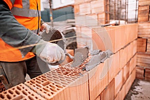 Close up details of industrial bricklayer installing bricks on industrial building