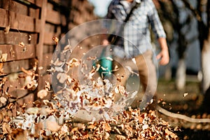 details of leaves swirling up when worker uses home leaf blower photo