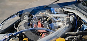 A close up details in the motor engine of a vehicle sport racer car with opened hood