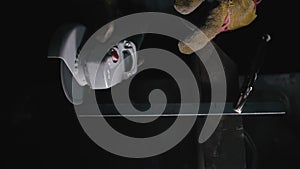 Close up details of sparks, industrial worker using angle grinder and cutting steel. Sparks fly straight in the camera