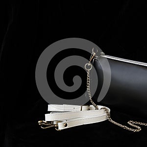 Close-up detal of leather handbag, always classic combination, black and white color with strap and chain. For modern photo