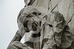 Close up of a deteriorating statue showing a person holding their head, symbolizing distress or defeat, A cracked and crumbling photo
