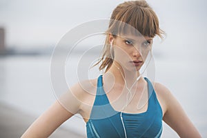 A close up of a determined woman athlete running by the seaside