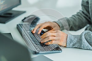 close up developer hand coding with keyboard on desk at modern office