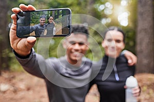 Close up of device screen taking selfie of happy young mixed race couple while out for a run in nature. Sporty young