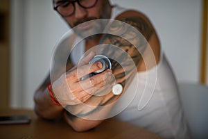 Close up of man using sensor applicator to insert the CGM sensor into his arm.