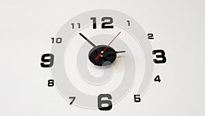 Close-up of a dial analog wall clock on a white wall