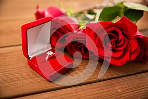 Close up of diamond engagement ring and red roses photo