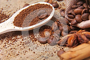 Close-up different types of coffee beans on wooden spoon, sticks of cinnamon and anise star, macro, set