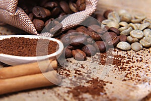 Close-up different types of coffee beans on wooden spoons, green coffee, sticks of cinnamon, macro, set