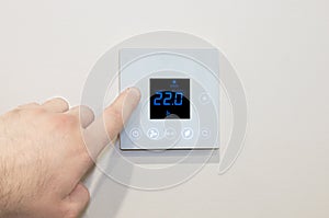 Close-up of a digital thermostat being adjusted