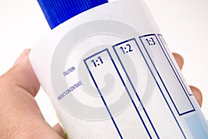 Close up a dilution ratio label of concentrated liquid chemicals on plastic bottles.
