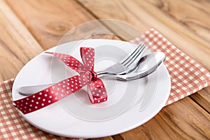 close up dinner setting fork and spoon on plate on wooden background