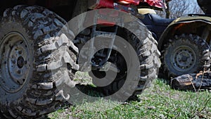 Close-up of dirt ATVs standing on the grass in the mountains. Smooth camera movement from left to right. Extreme type of