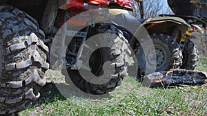 Close-up of dirty ATV wheels on the background of the mountains. Side view from behind. Extreme type of outdoor