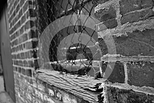 Close up of a dirty broken boarded up window sill on an abandoned building black and white