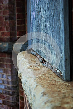 Close up of a dirty broken boarded up window sill on an abandoned building