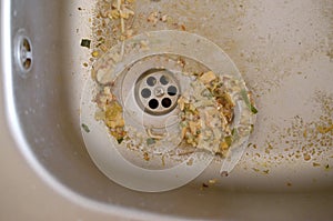 Close up on dirty clogging kitchen sink drain with food particles