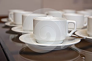 Close up dirty coffee cup and spoon setting on white saucer and wooden table after drinking in the morning in vintage style. cup