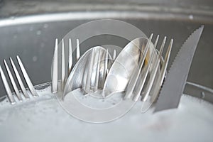 Close up of dirty dishes washing in kitchen sink