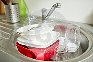 Close up of dirty dishes washing in kitchen sink