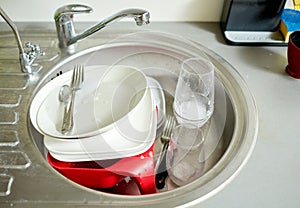 Close up of dirty dishes washing in kitchen sink