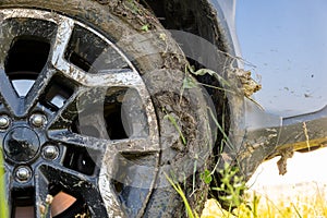 Close up of dirty off road car wheels with dirty tires covered with yellow mud